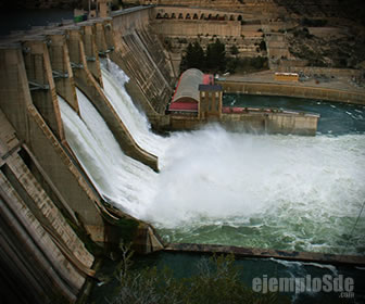 Presa con agua descendiendo por sus aliviaderos hacia el cauce inferior